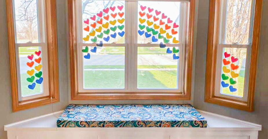 Window seat with hearts across the window panes in a beautiful rainbow. Photo by Paige Knipfer